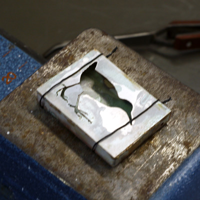 Juuri juotettu hopea riipus jäähtymässä.